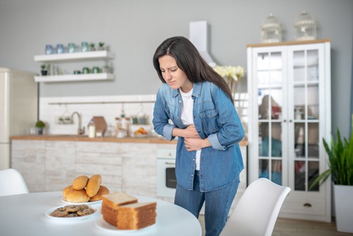Health issues. A woman having a stomach ache because of gluten sensitivity