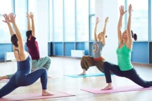 group-of-sporty-people-practicing-balance-exercise-on-the-floor