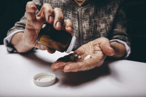 cropped-view-of-elderly-woman-taking-prescription-medicine-from-pill-bottle-senior-fem