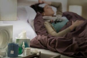 tissueflu-medicines-and-tea-on-bedside-table-sick-woman