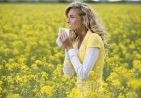 woman in a field of pollen holding a tissue because of bad allergies