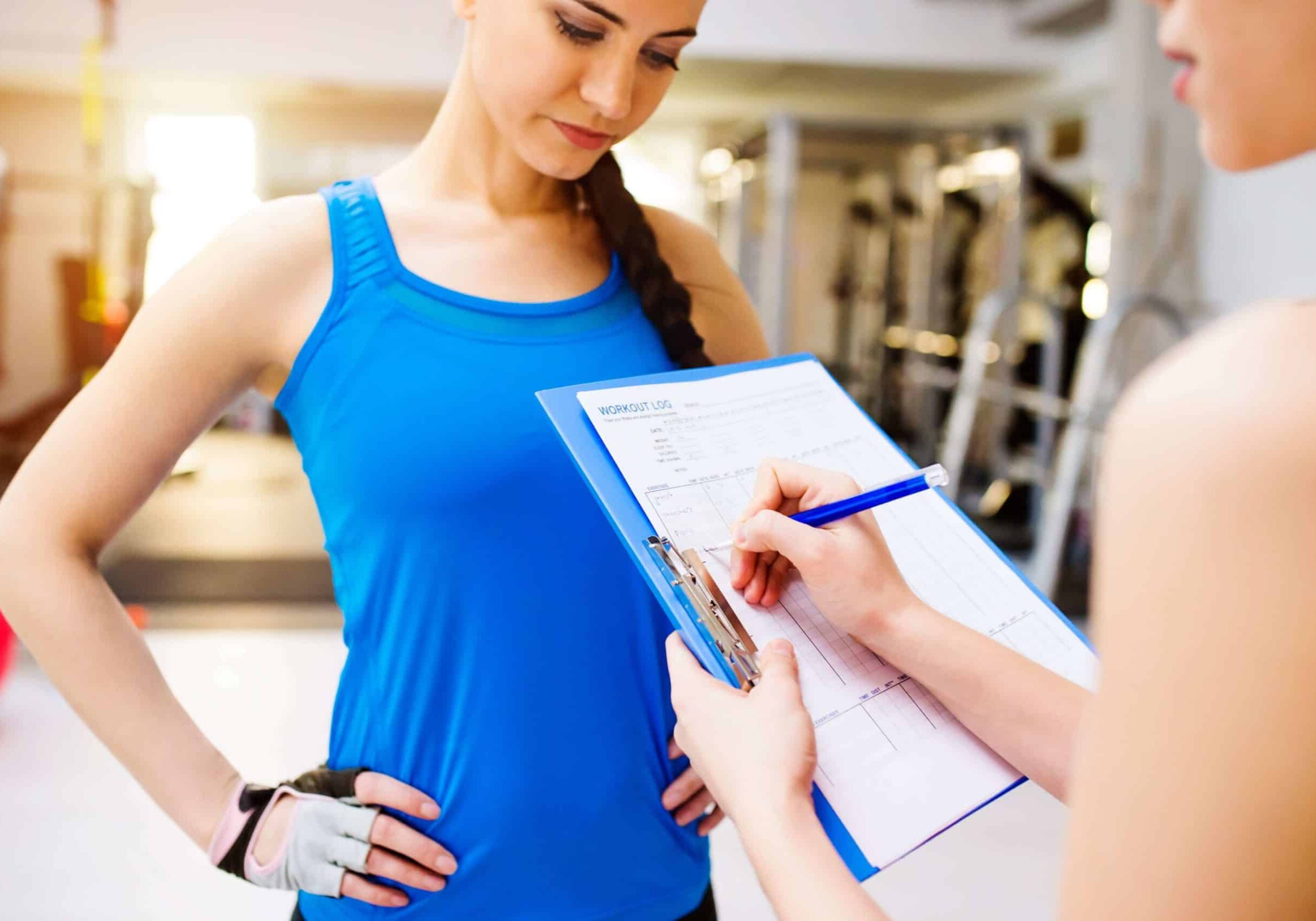 close up of a fit woman her personal trainer in a gym