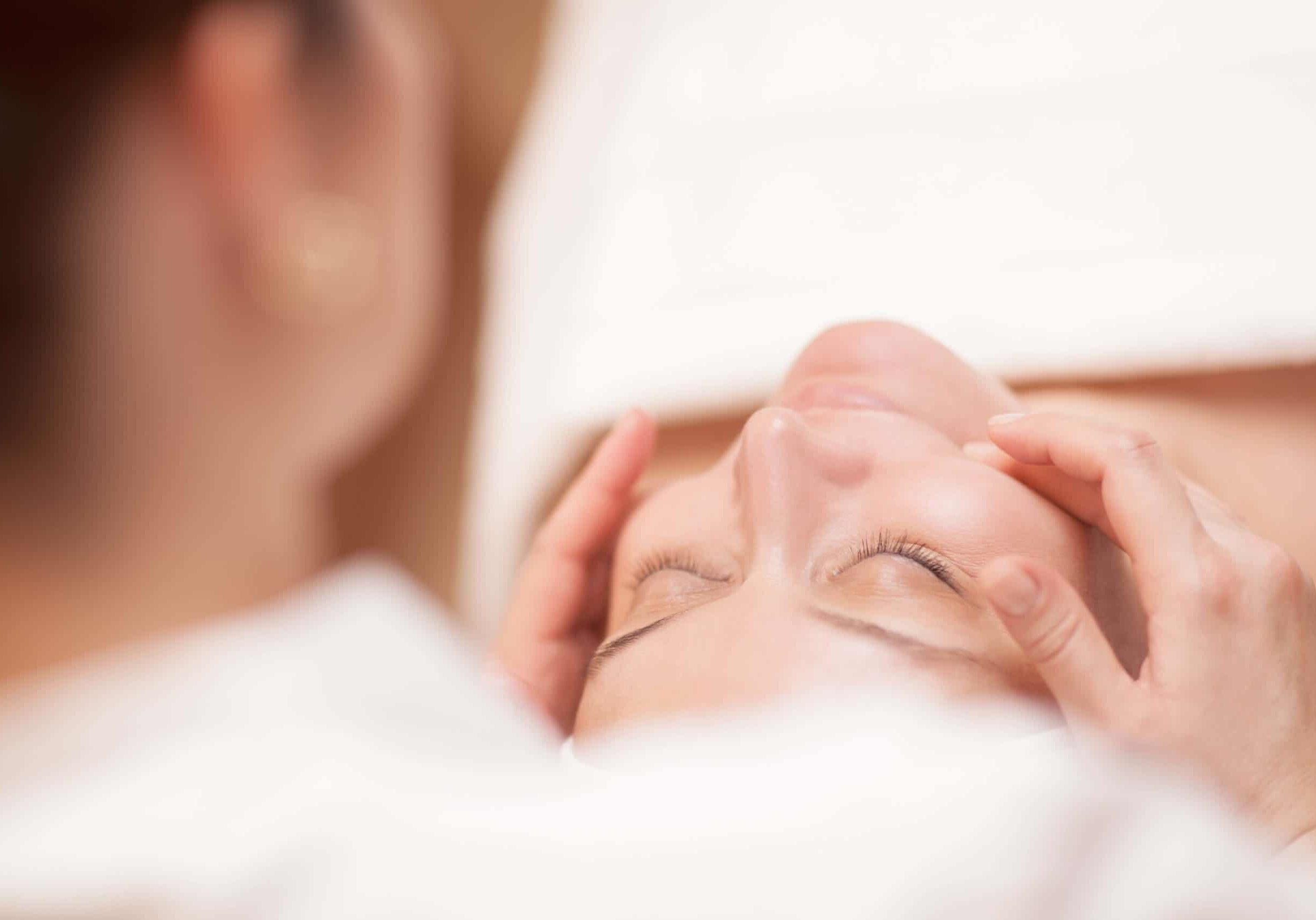 women receiving a facial massage from an esthetician